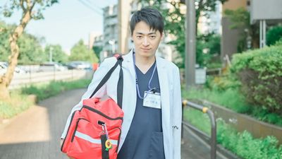 監修医師 大澤基の写真(白衣・往診バッグを持った屋外でのポートレート)